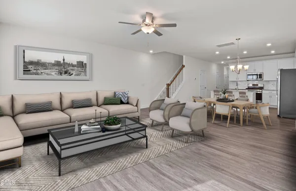 a living room with furniture a wooden floor and a chandelier