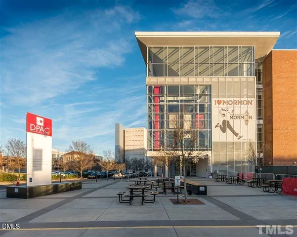 a view of a building with car parked on the road