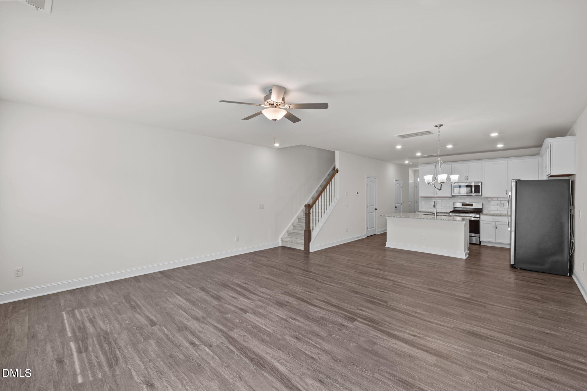 1033 Heartstone Way Durham, NC 27713 - Photo 3 of 26 a view of an empty room with wooden floor and a ceiling fan