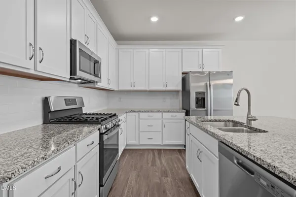 a kitchen with stainless steel appliances granite countertop a sink stove and refrigerator