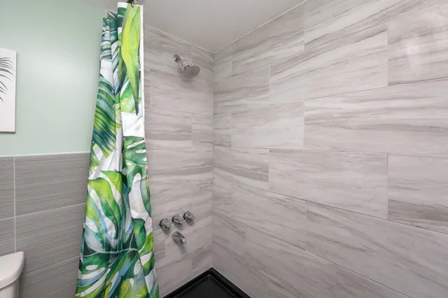 a bathroom with a toilet and a shower