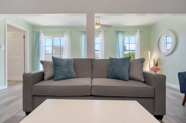 a living room with furniture mirror and a large window