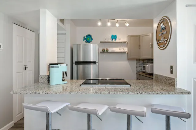 a kitchen with kitchen island granite countertop a table and a stove