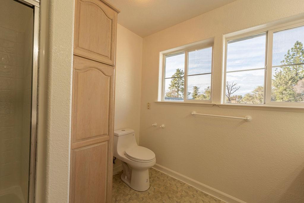 10246 Ranch Road Rough and Ready, CA 95975 - Photo 46 of 69 a white toilet sitting in a bathroom next to a window