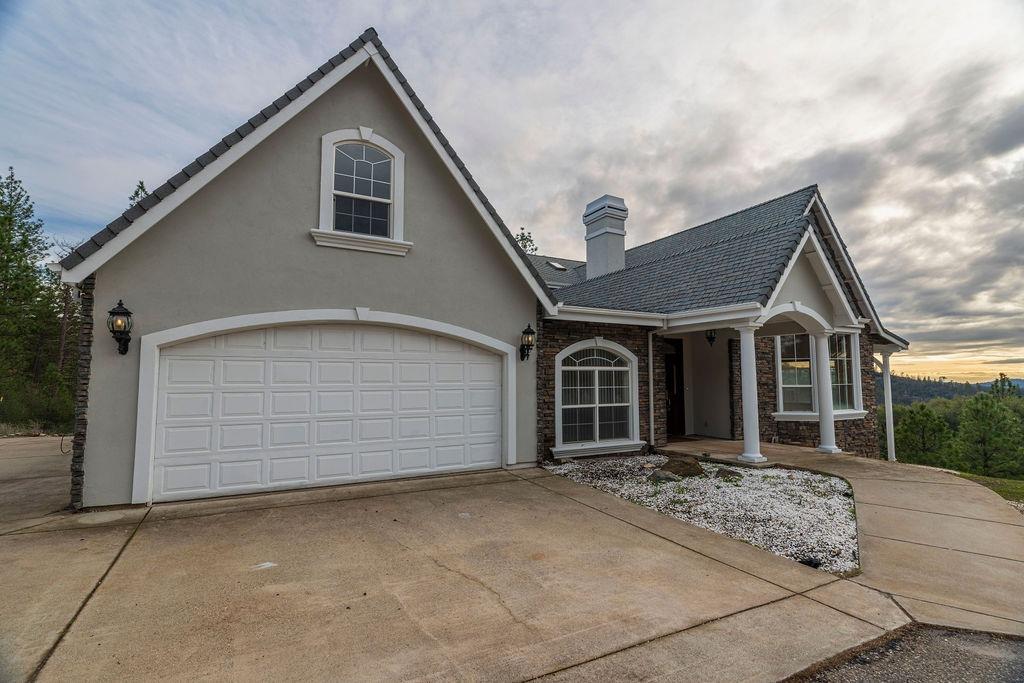 10246 Ranch Road Rough and Ready, CA 95975 - Photo 56 of 69 a front view of a house with a yard and garage