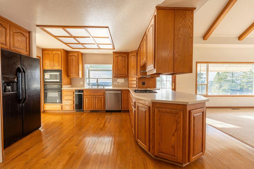 10246 Ranch Road Rough and Ready, CA 95975 - Photo 7 of 69 a kitchen with stainless steel appliances granite countertop a refrigerator a sink dishwasher and a stove with wooden floor