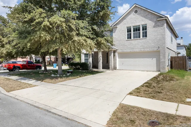 a front view of a house with cars parked