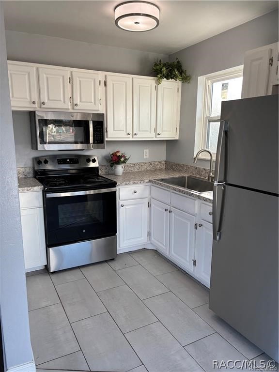 405 Copperfield Road Spring Hill, FL 34606 - Photo 9 of 25 a kitchen with cabinets stainless steel appliances and a counter space