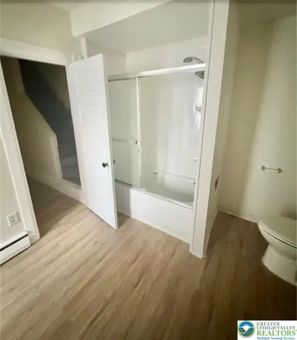a view of a livingroom with wooden floor and a window