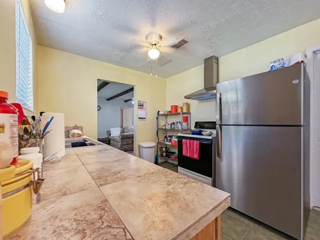 a kitchen with stainless steel appliances granite countertop a refrigerator a stove and a sink