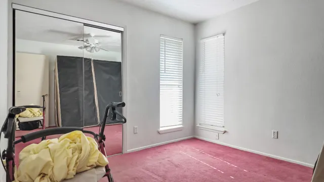 a bedroom with furniture and a fan