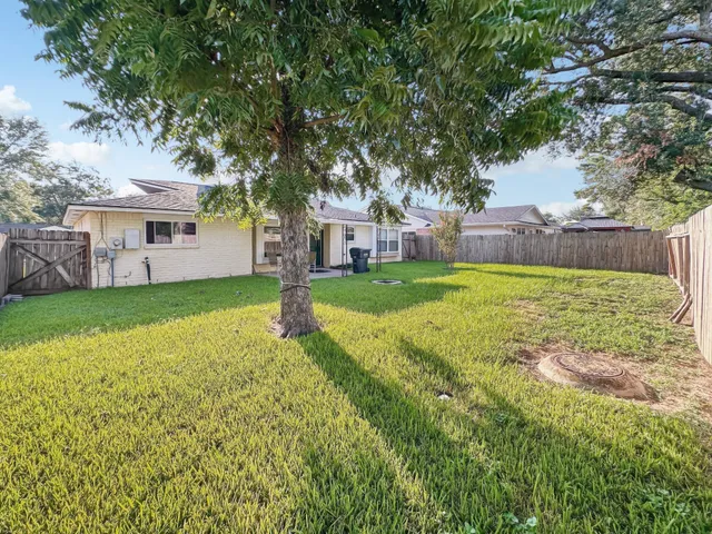 a view of a house with a big yard and large trees