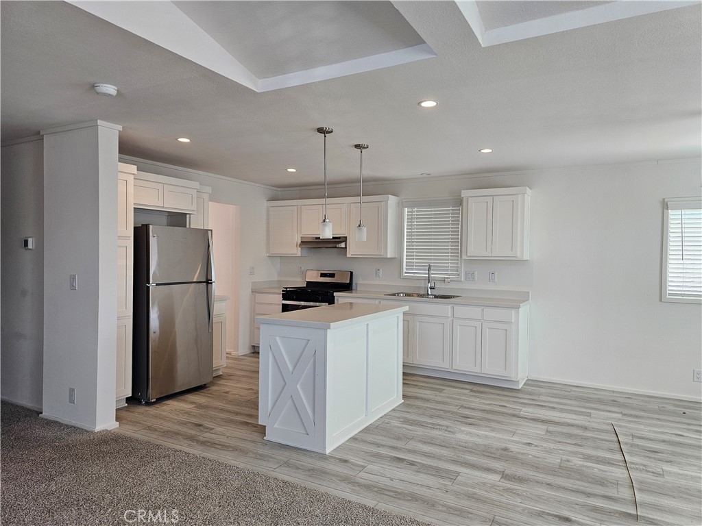 1560 Massachusetts Avenue, Unit 94 Riverside, CA 92507 - Photo 6 of 14 a large kitchen with stainless steel appliances granite countertop a stove a sink and a refrigerator