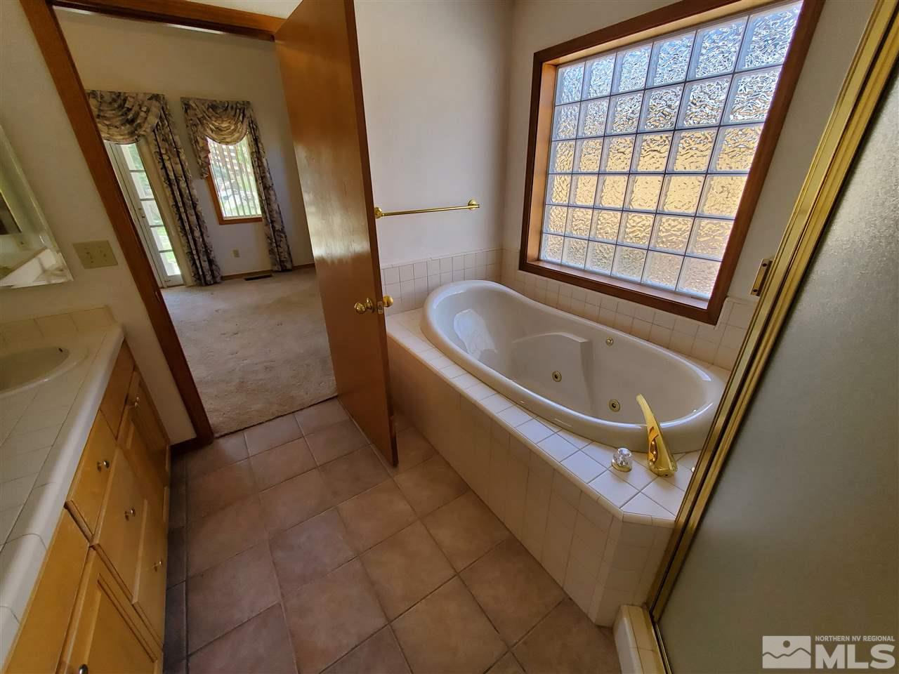 12650 Buckthorn Lane Reno, NV 89511 - Photo 13 of 20 a bath tub sitting in a bathroom next to a window