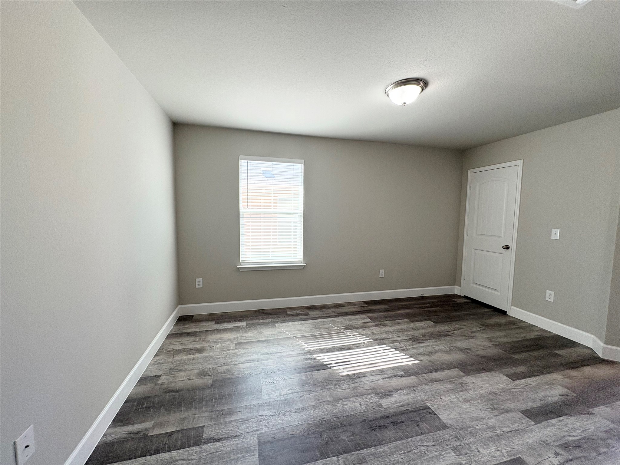 11708 Cambrian Road Manor, TX 78653 - Photo 12 of 31 Ample room with wood-look flooring and a window offering natural light, perfect for any use.