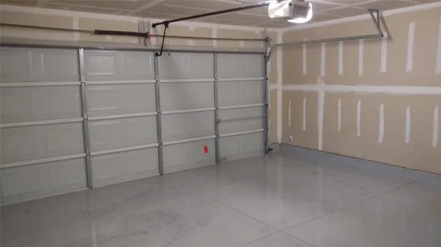 an empty room with wooden floor and fan