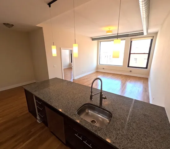 a kitchen with granite countertop a sink a stove and a wooden floor