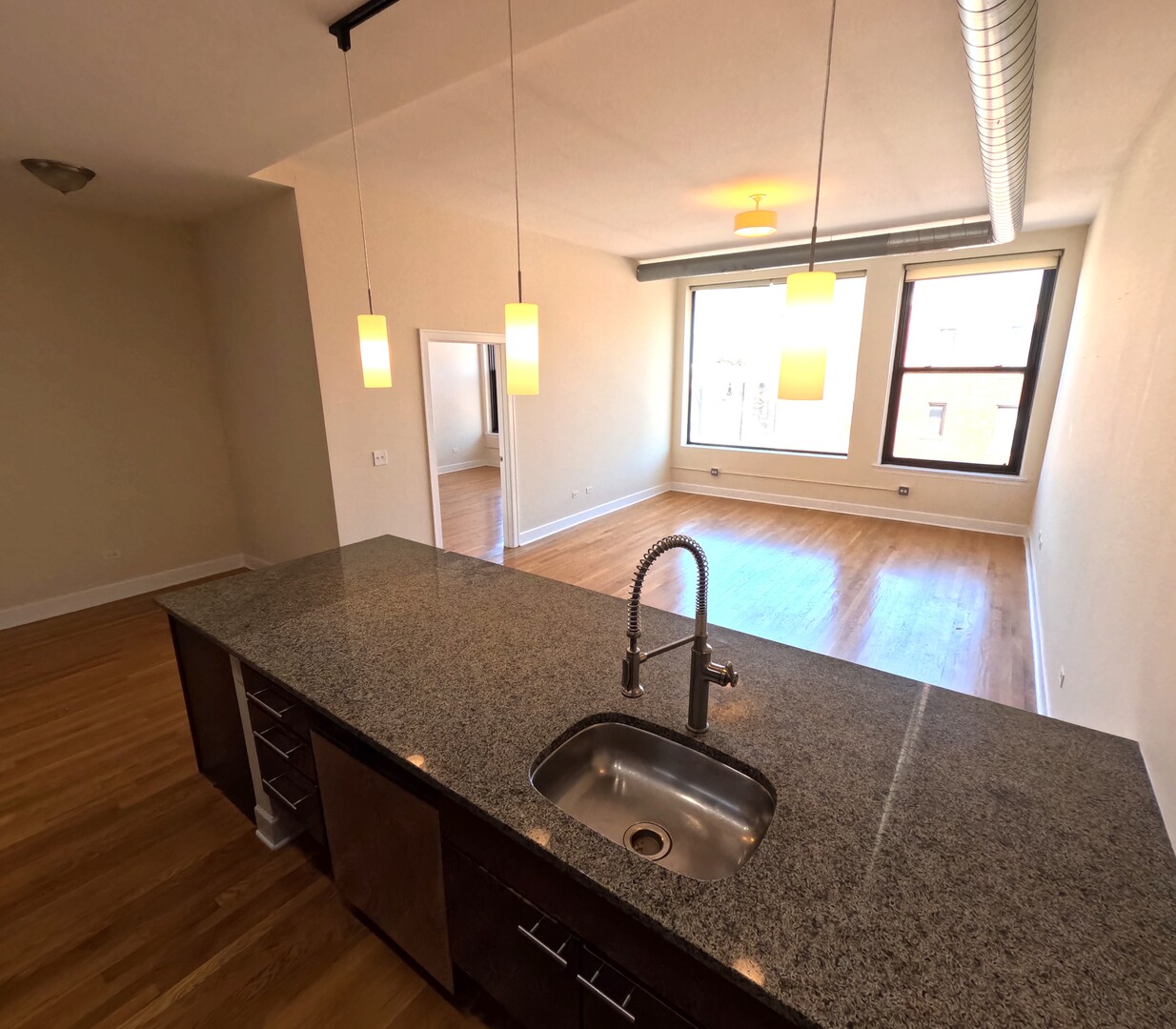 2778 North Milwaukee Avenue, Unit 308 Chicago, IL 60647 - Photo 11 of 18 a kitchen with granite countertop a sink a stove and a wooden floor