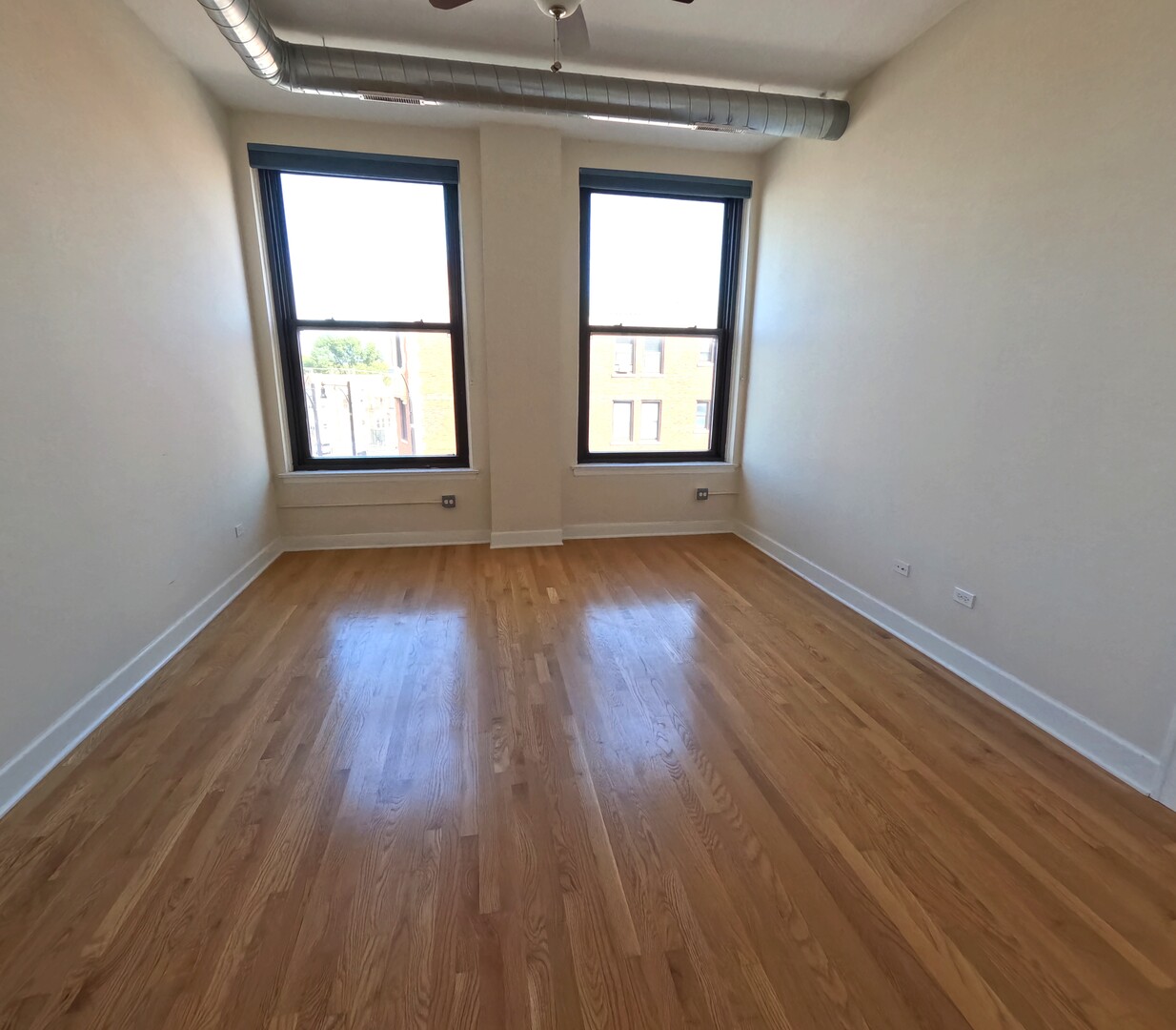2778 North Milwaukee Avenue, Unit 308 Chicago, IL 60647 - Photo 17 of 18 an empty room with wooden floor and windows