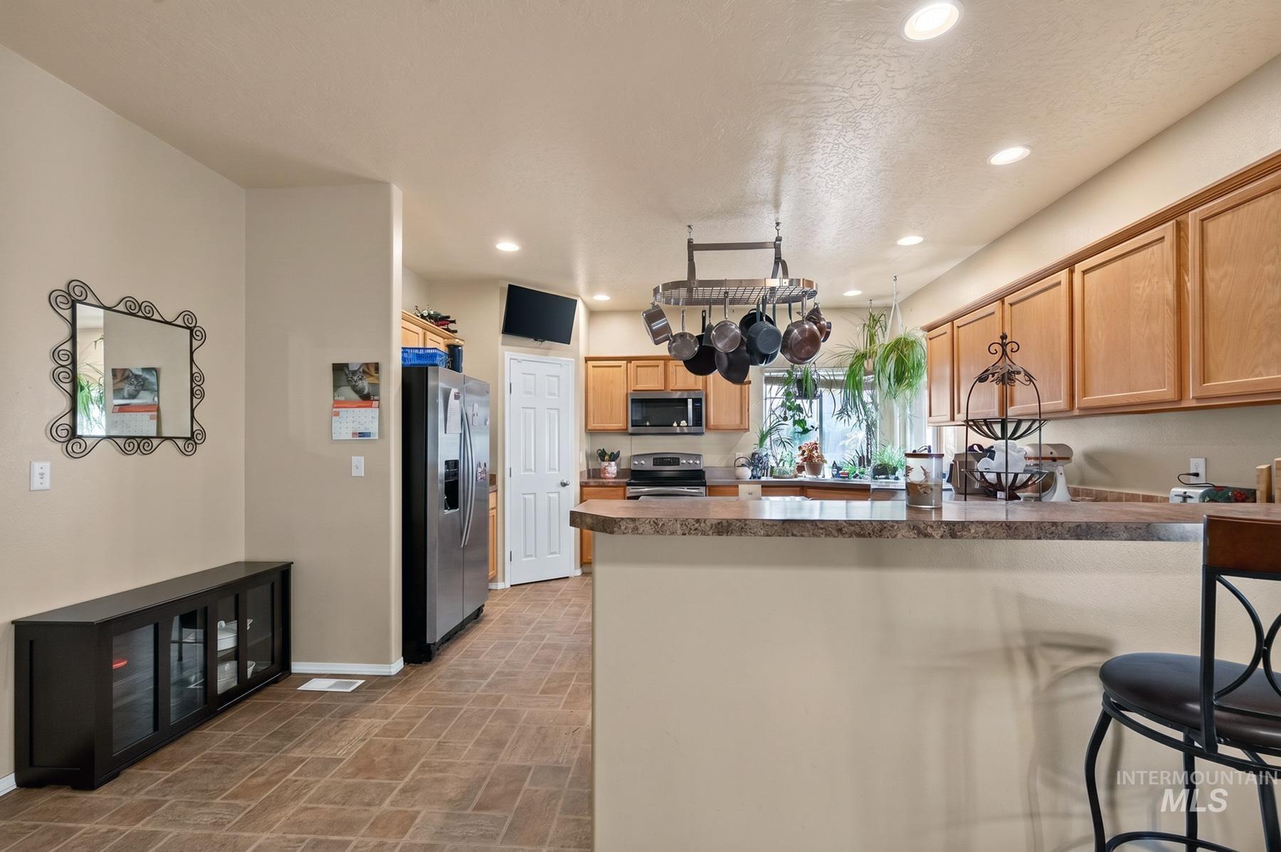 5020 Northrup Way Caldwell, ID 83607 - Photo 14 of 36 Kitchen featuring a peninsula counter with seating, recessed lighting, and wood cabinetry
