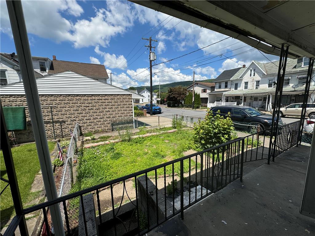 200 South Coal Street Shamokin, PA 17872 - Photo 15 of 18 An elevated front porch looks out over a fenced yard toward the neighborhood beyond.