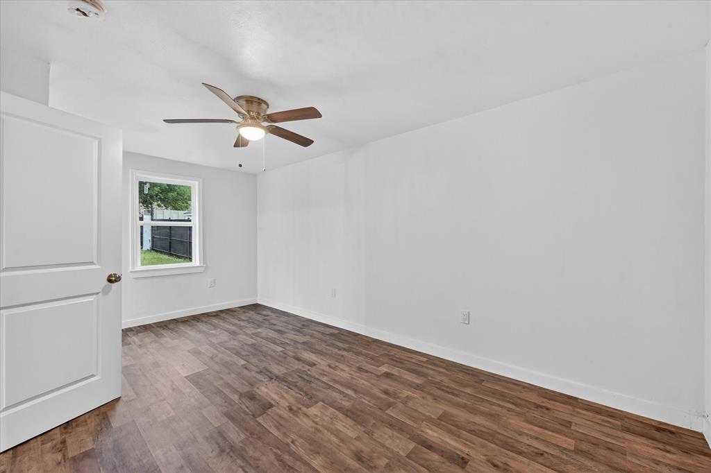 538 Pemberton Hill Road Dallas, TX 75217 - Photo 15 of 31 Spacious room featuring wood-finish flooring, white walls, and a ceiling fan with integrated lighting