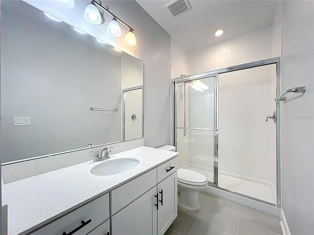 a spacious bathroom with a double vanity sink mirror and shower