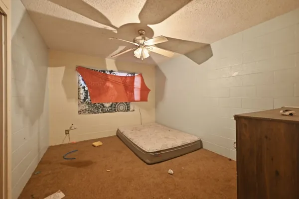 an empty room with a ceiling fan and a window