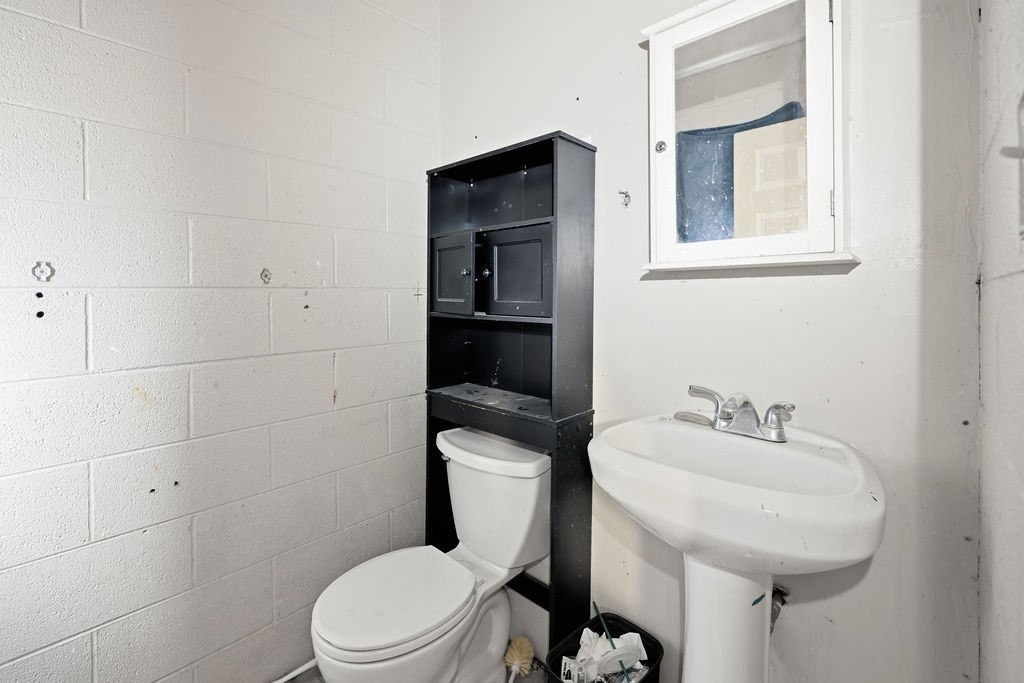 508 South Kenneth Avenue Monahans, TX 79756 - Photo 18 of 39 a bathroom with a toilet a sink and mirror