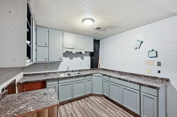 a kitchen with granite countertop a sink stainless steel appliances and cabinets