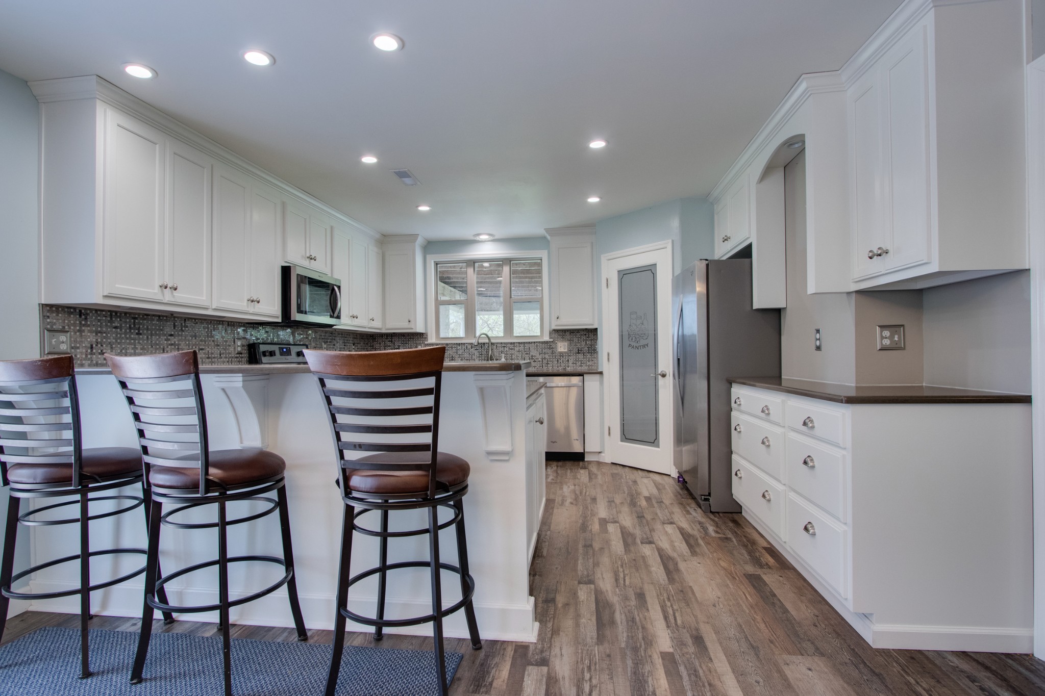 445 Tracy Road Watertown, TN 37184 - Photo 10 of 49 a kitchen with stainless steel appliances white cabinets and wooden floors
