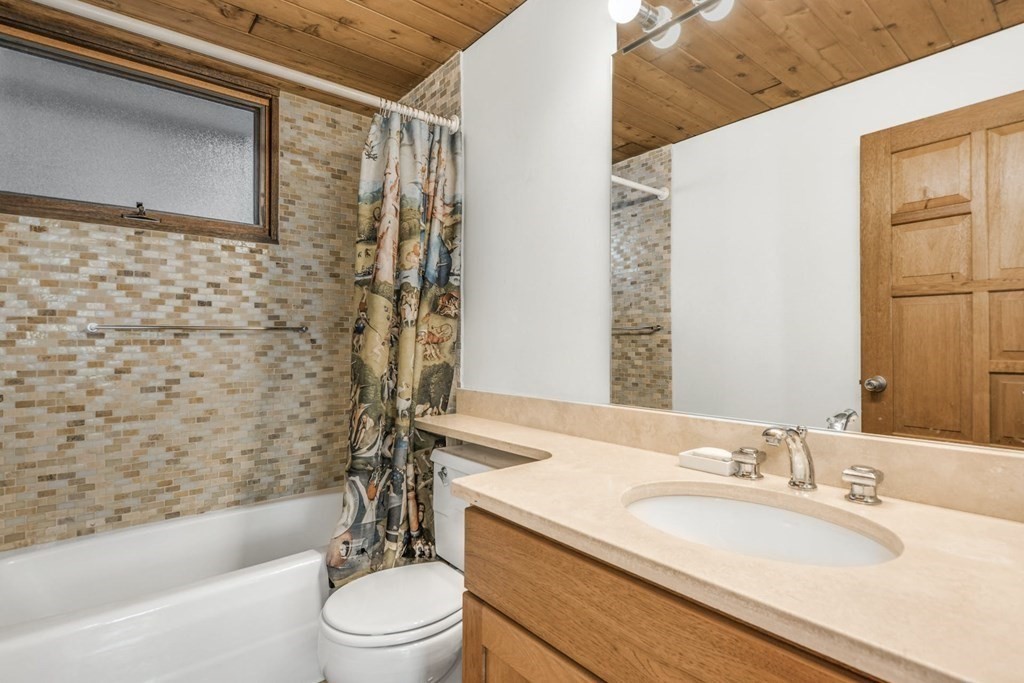 246 Heald Road Carlisle, MA 01741 - Photo 17 of 25 a bathroom with a granite countertop sink toilet a mirror and shower