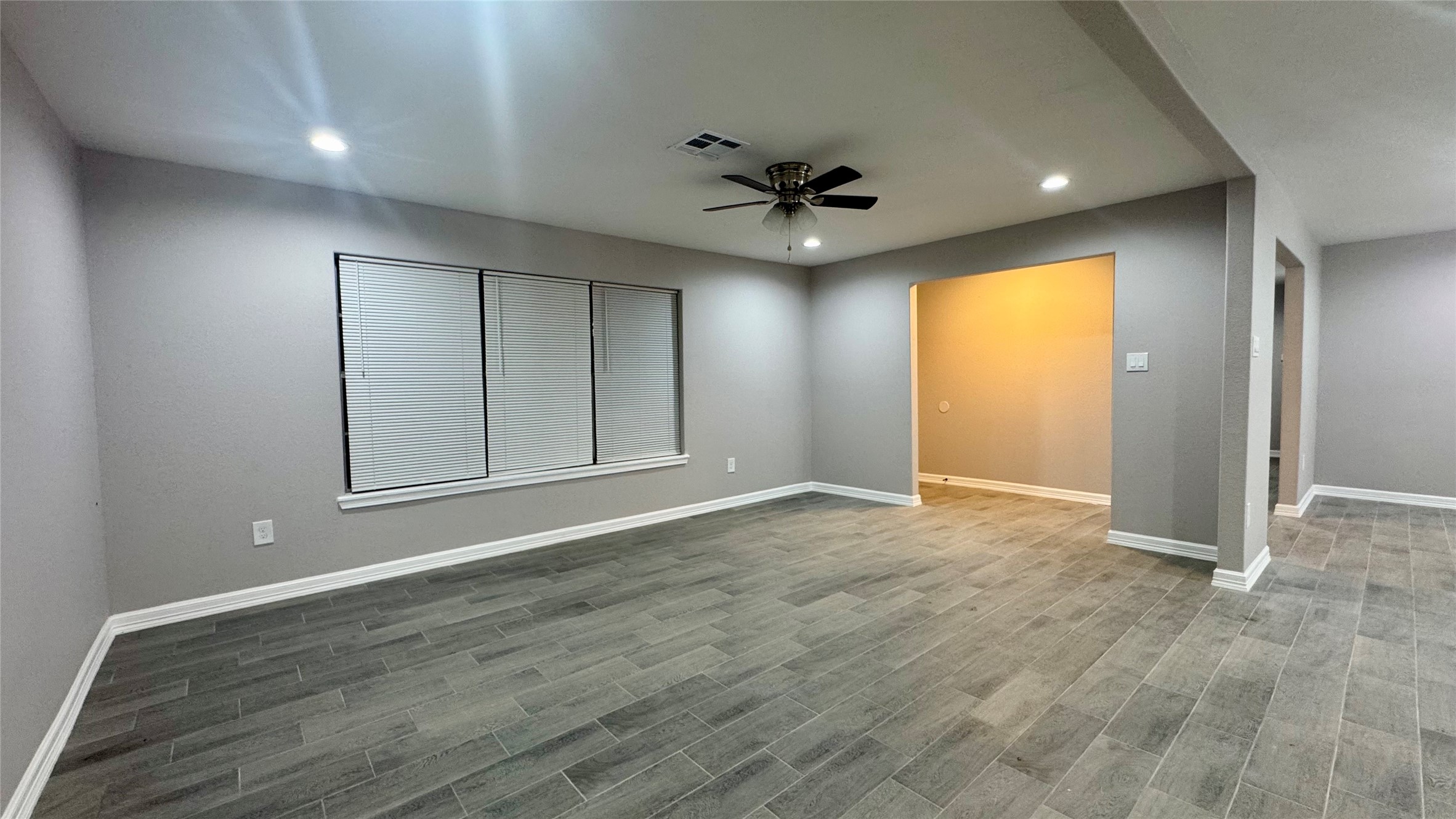 202 Massey Tompkins Road Baytown, TX 77521 - Photo 2 of 20 an empty room with wooden floor and a ceiling fan