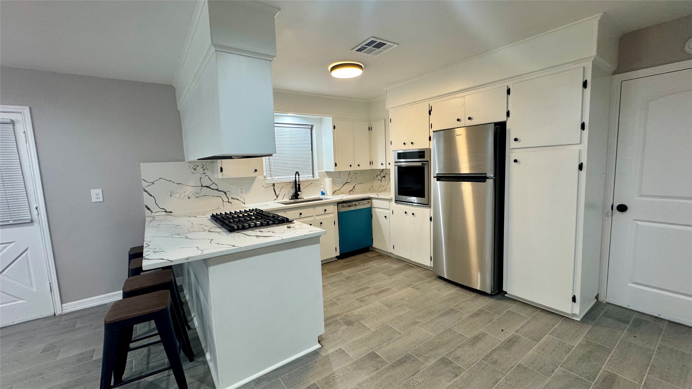 202 Massey Tompkins Road Baytown, TX 77521 - Photo 3 of 20 a kitchen with a stove a refrigerator and white cabinets