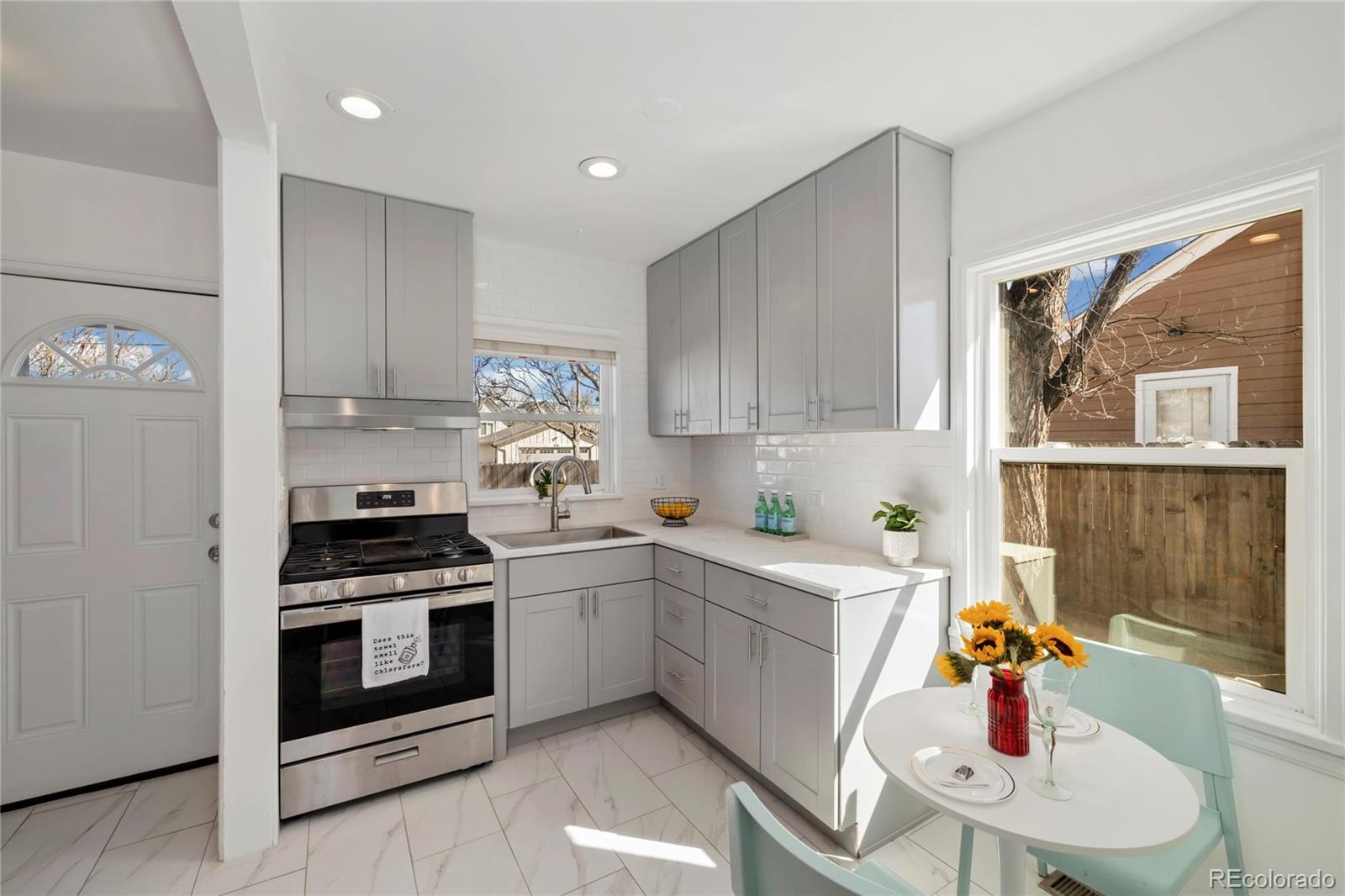 2570 Jay Street Edgewater, CO 80214 - Photo 11 of 26 a kitchen with stainless steel appliances kitchen island granite countertop a sink cabinets and wooden floor