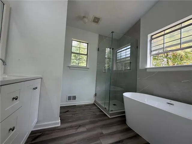 a bathroom with a sink a window and wooden floor