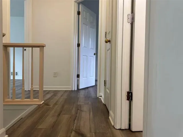 a view of a hallway with wooden floor and staircase