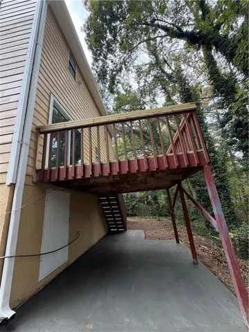 a view of wooden house with a car parked