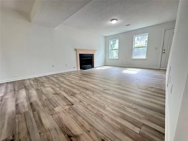 an empty room with windows and fireplace