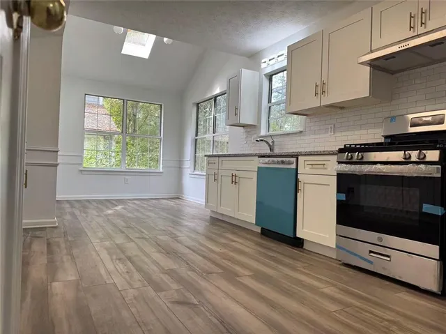 a kitchen with stainless steel appliances granite countertop a stove and a sink