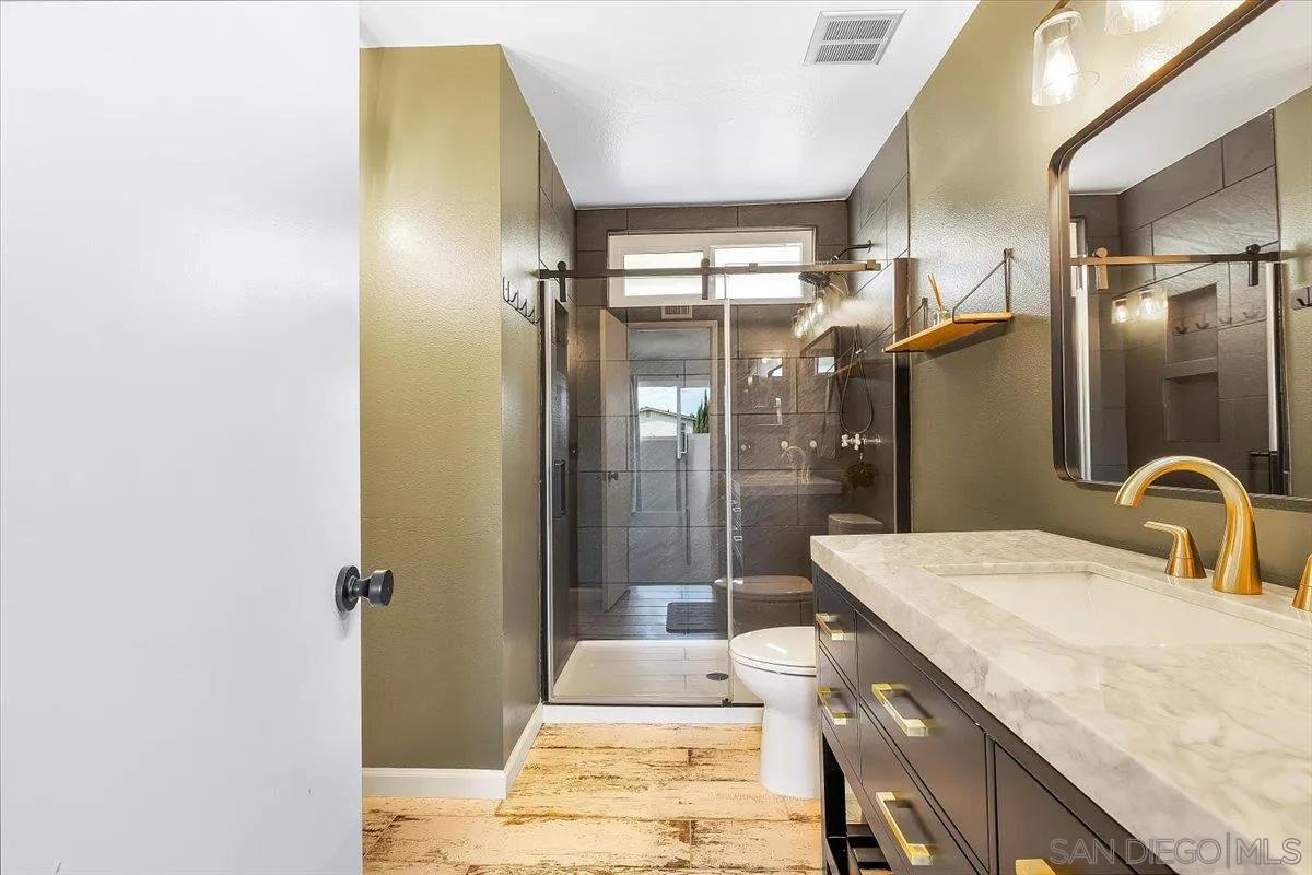 8335 Carlton Oaks Drive Santee, CA 92071 - Photo 26 of 32 a bathroom with a granite countertop sink and a mirror