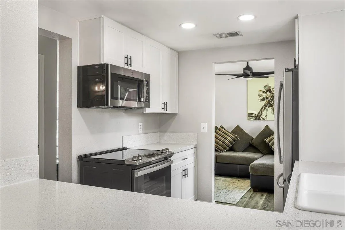 8335 Carlton Oaks Drive Santee, CA 92071 - Photo 9 of 32 a kitchen with stainless steel appliances granite countertop a stove and a refrigerator