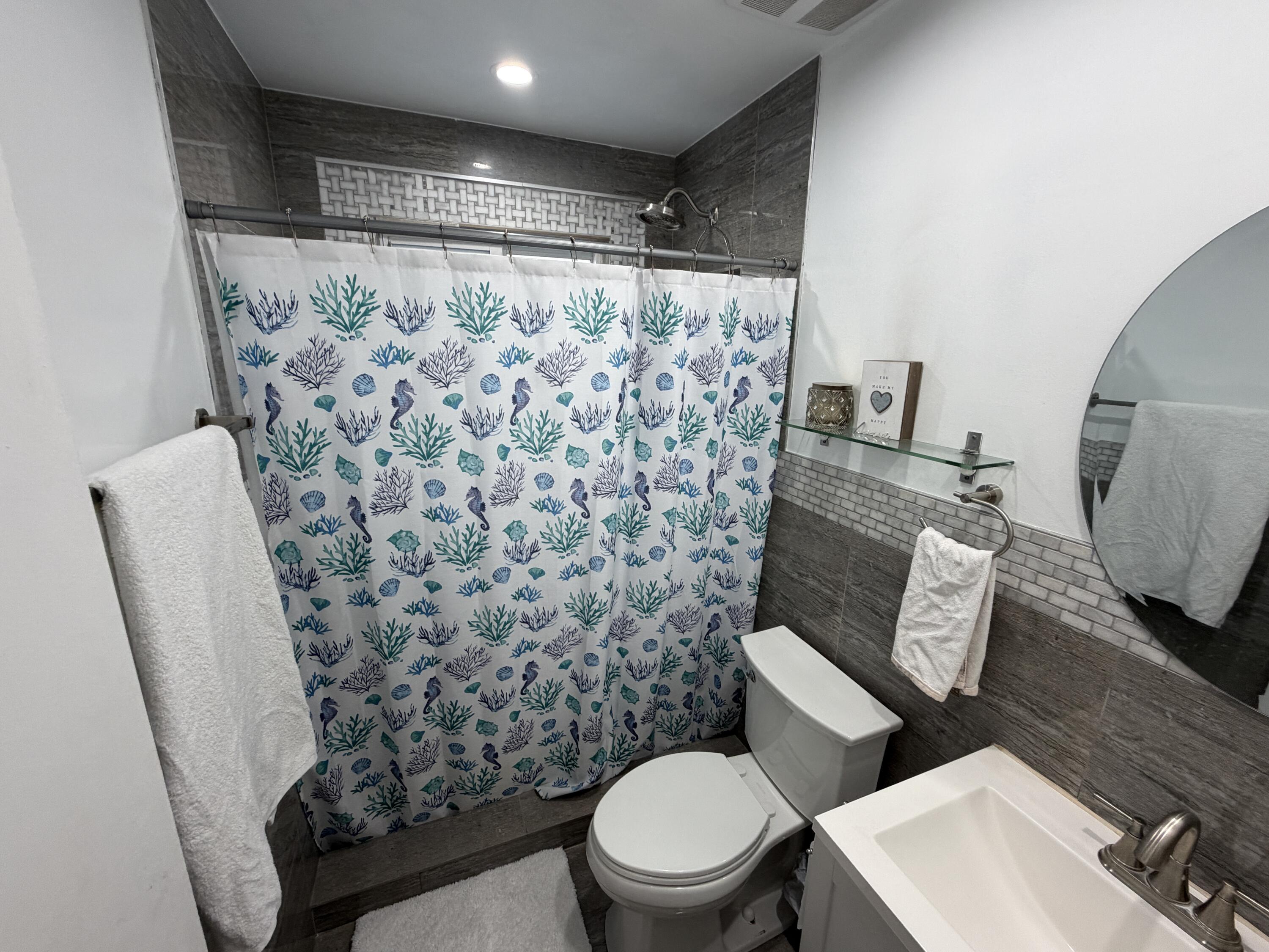 8097 Cedar Hollow Lane Boca Raton, FL 33433 - Photo 23 of 36 a bathroom with a toilet and shower curtain