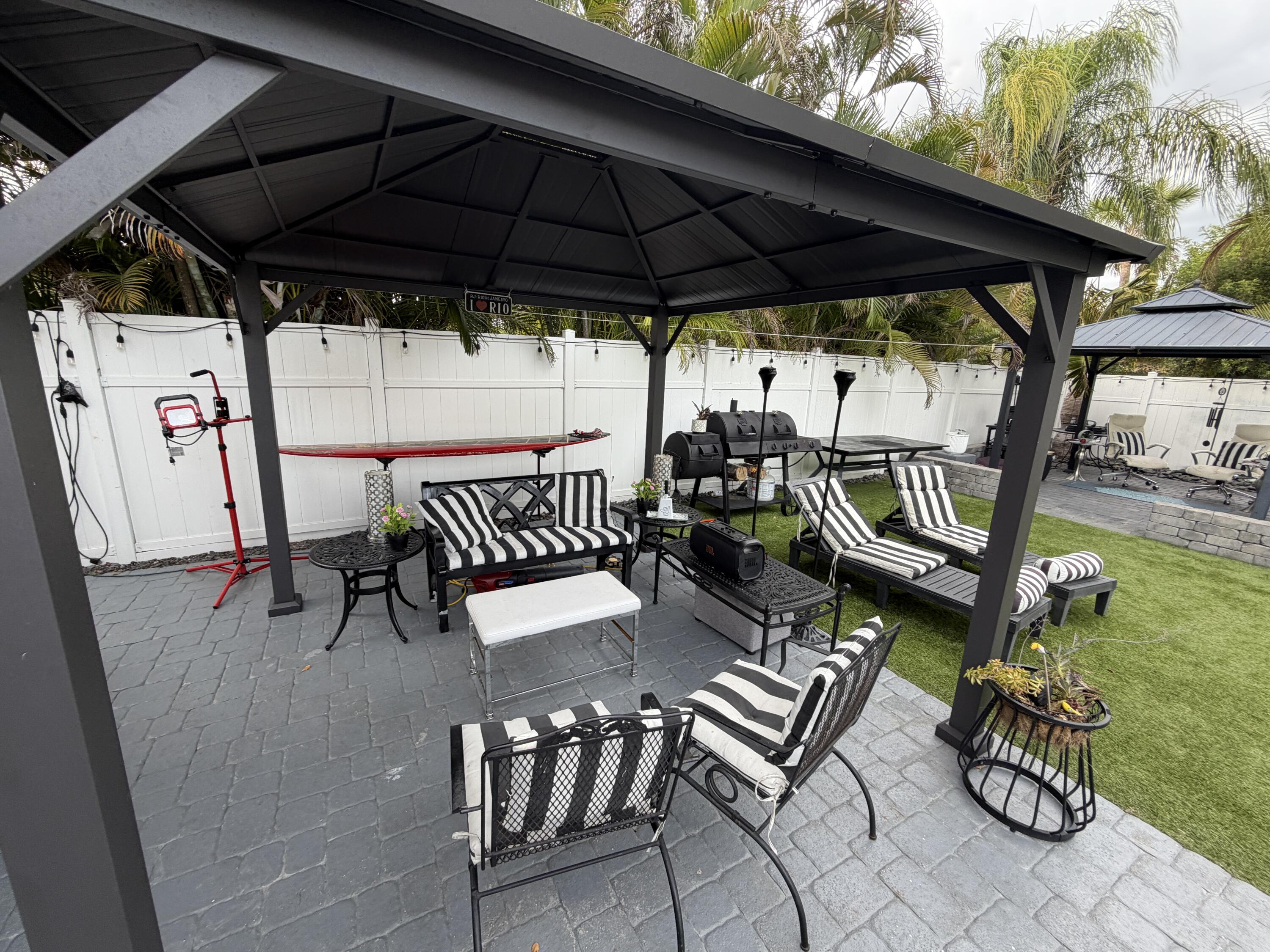 8097 Cedar Hollow Lane Boca Raton, FL 33433 - Photo 28 of 36 a view of a patio with a table and chairs under an umbrella
