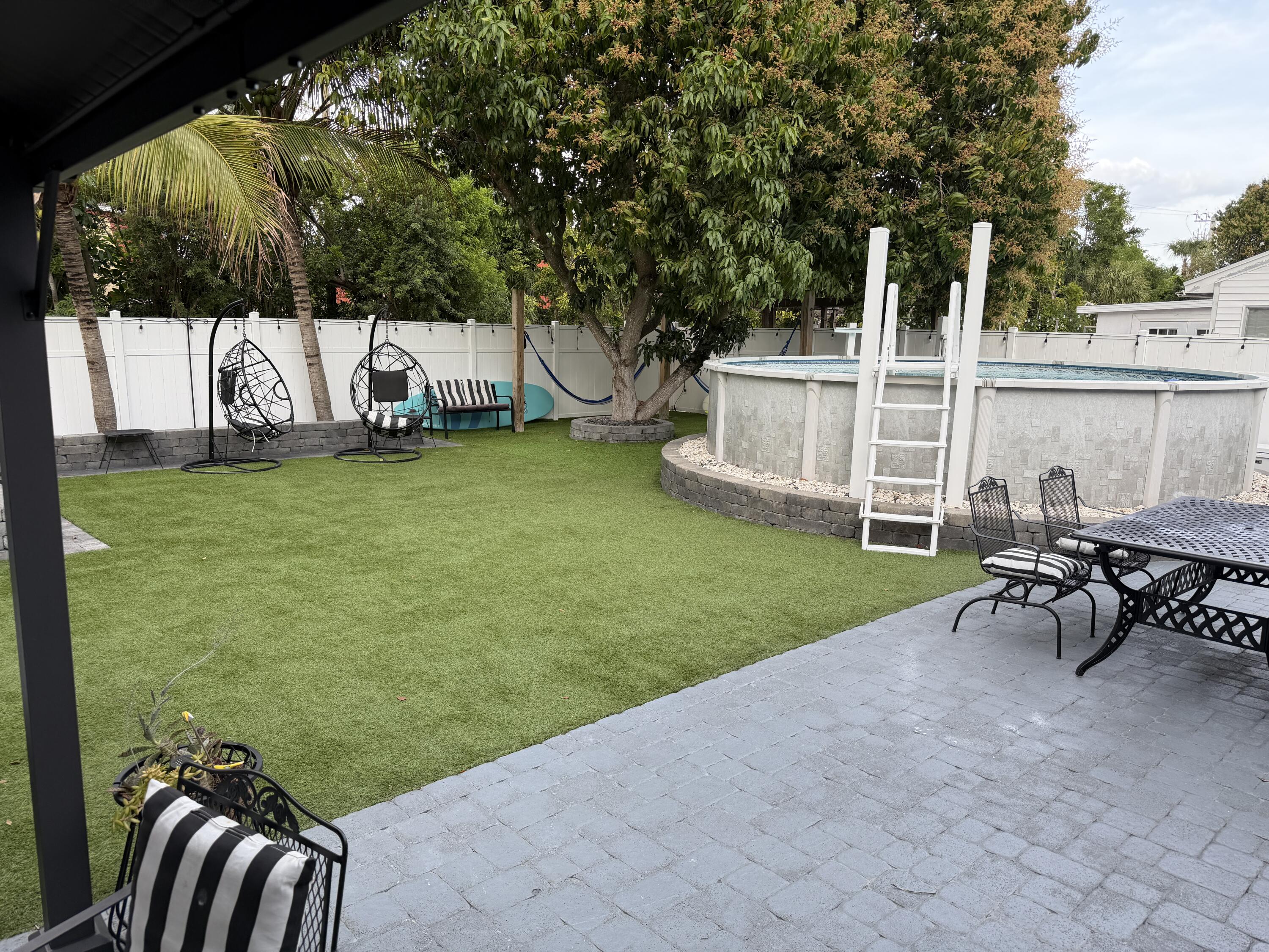 8097 Cedar Hollow Lane Boca Raton, FL 33433 - Photo 30 of 36 a view of a patio with table and chairs and a big yard