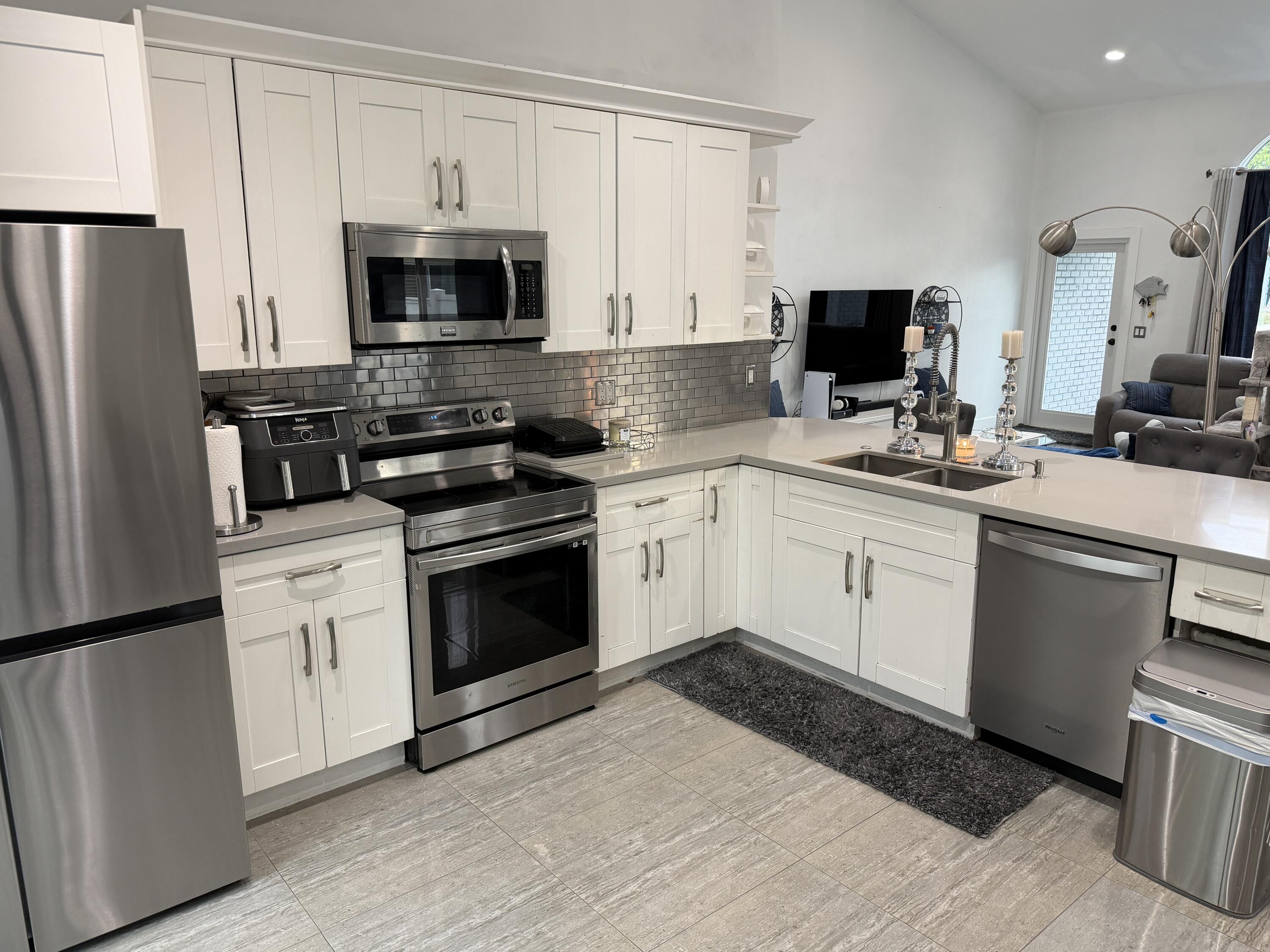 8097 Cedar Hollow Lane Boca Raton, FL 33433 - Photo 3 of 36 a kitchen with a sink stove and microwave