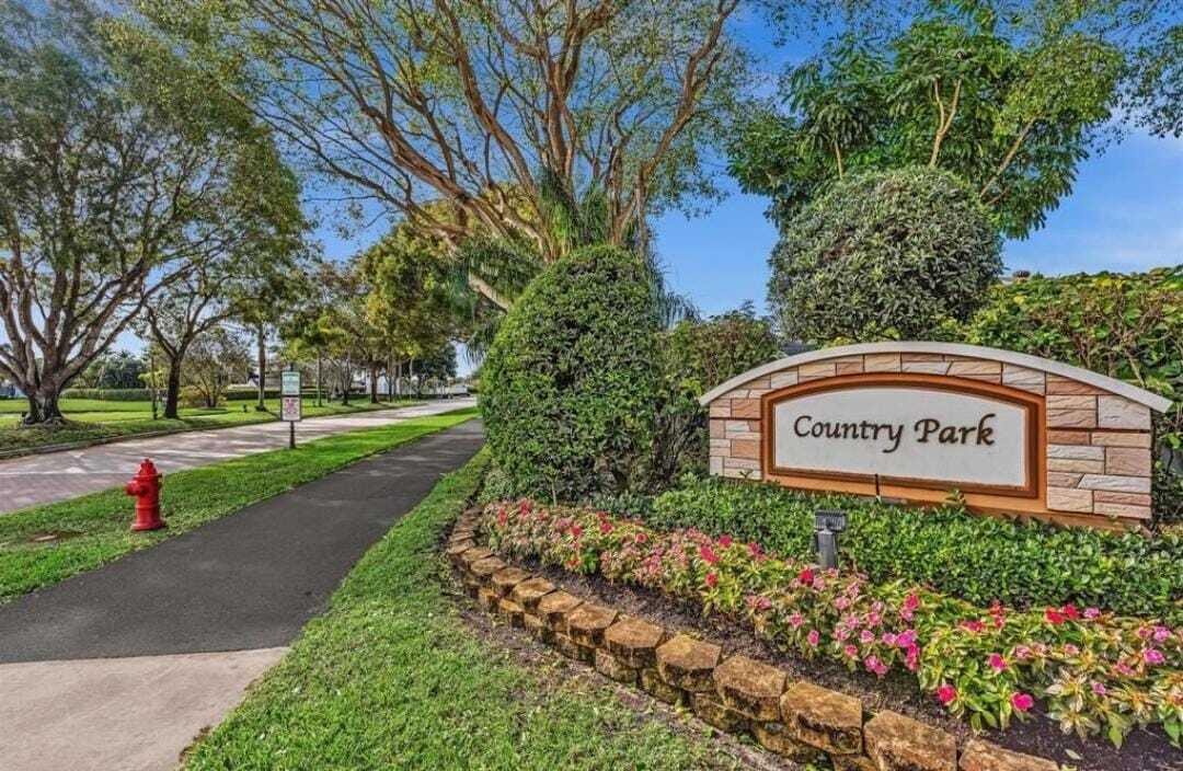 8097 Cedar Hollow Lane Boca Raton, FL 33433 - Photo 33 of 36 a sign that is sitting in front of flowers