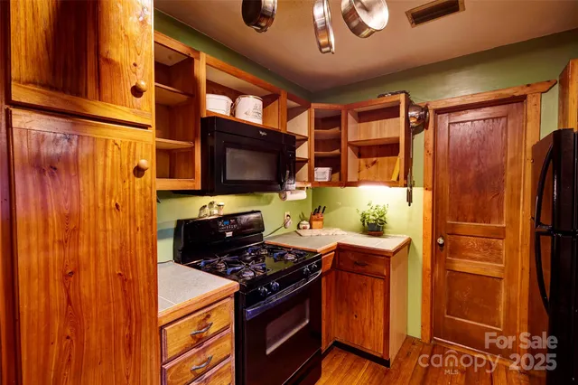 a kitchen with stainless steel appliances granite countertop a stove top oven a refrigerator and a microwave