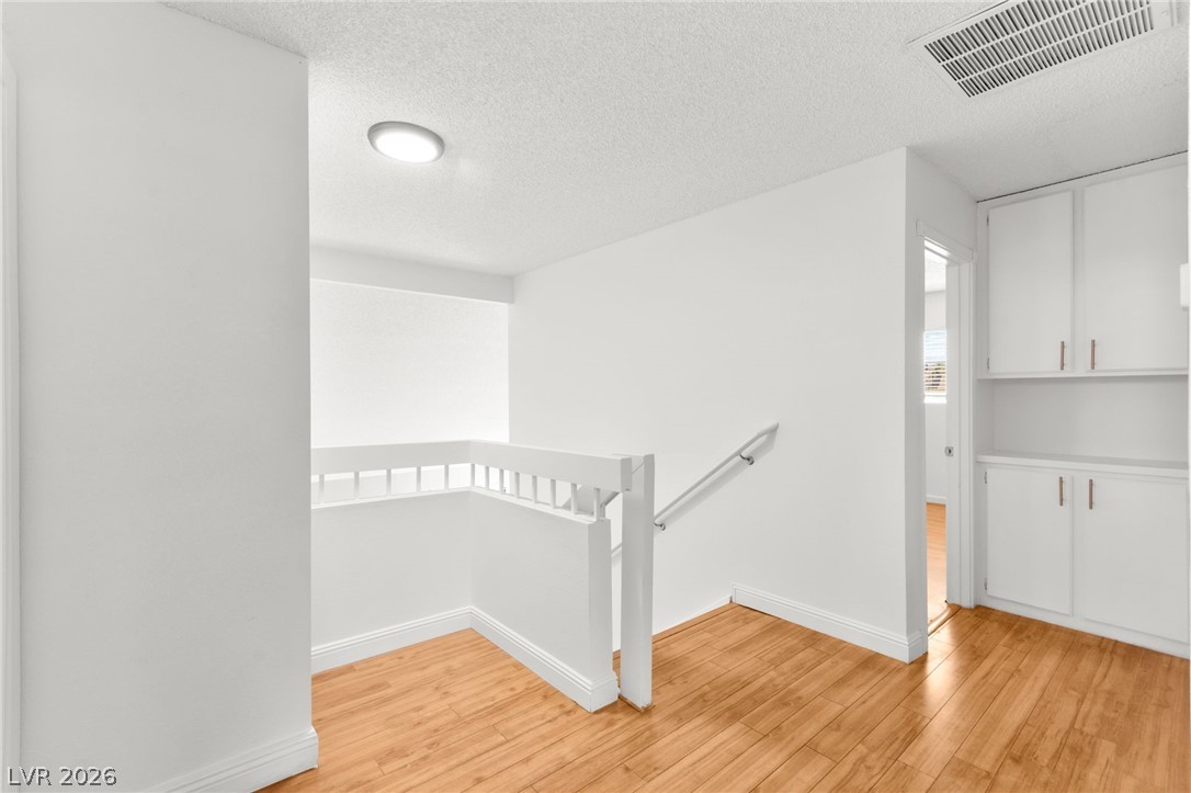 4430 Cranbrook Way Las Vegas, NV 89103 - Photo 32 of 50 Clean lines and wood flooring define this bright upper landing with built-in storage.