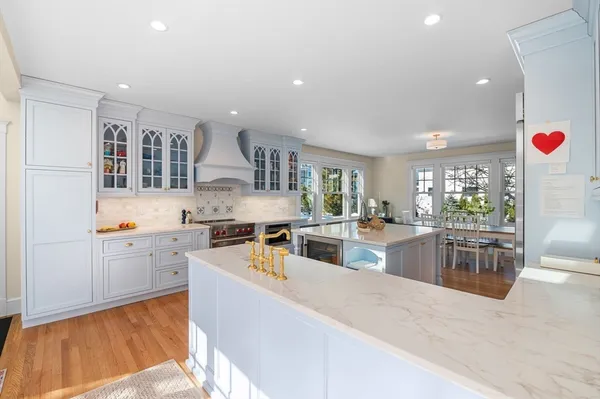 a large kitchen with stainless steel appliances kitchen island granite countertop a large kitchen island a stove a sink a dining table and chairs